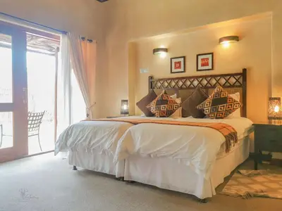 a bedroom with a large bed and a large window at Nyala's Corner @ Zebula in Mabula