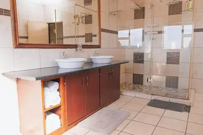 a bathroom with two sinks and a shower at Ray of sunshine in Centurion