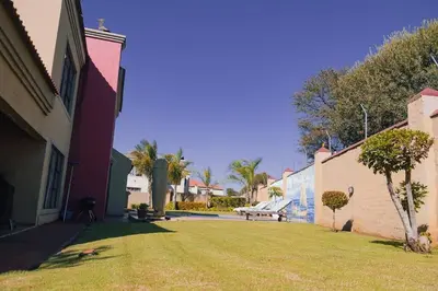 a yard with a bench next to a building at Ray of sunshine in Centurion