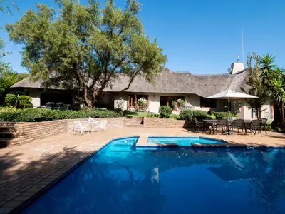 a swimming pool in front of a house at Celtis Manor Guesthouse in Midrand