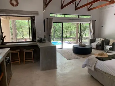 a large room with a bed and a living room at Pango Kruger Home For 2 in Marloth Park