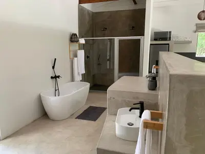 a bathroom with a white tub and a sink and a bath tub at Pango Kruger Home For 2 in Marloth Park