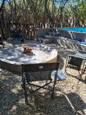 a table and a chair next to a pool at marlothpride in Marloth Park