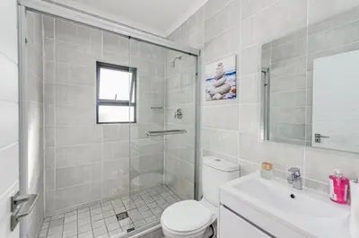 a bathroom with a shower and a toilet and a sink at Luxury apartment in Kyalami in Midrand