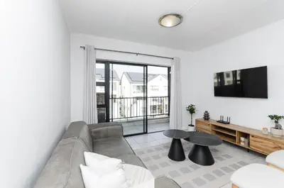 a living room with a couch and a tv at Luxury apartment in Kyalami in Midrand