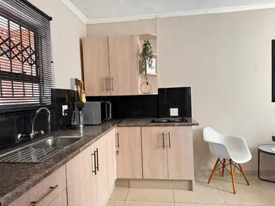 a kitchen with wooden cabinets and a sink at Pride studio @ The Monarch in Polokwane