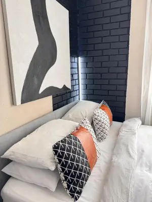 a bed with pillows on it next to a painting at Pride studio @ The Monarch in Polokwane