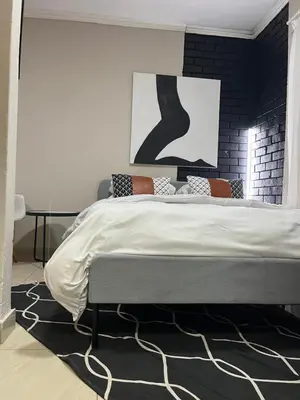 a bedroom with a large bed with a black wall at Pride studio @ The Monarch in Polokwane