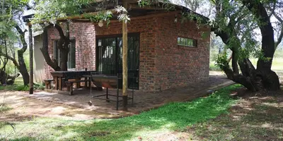 a small brick building with a table and a grill at Die Boshuisie in Rayton