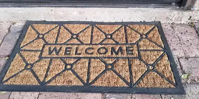 a welcome sign on a metal grate on the sidewalk at Die Boshuisie in Rayton