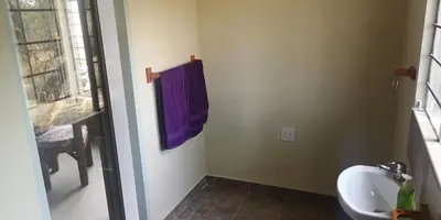 a bathroom with a sink and a purple towel at Die Boshuisie in Rayton