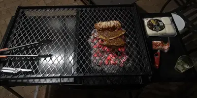 a grill with hamburgers and other food on it at Die Boshuisie in Rayton