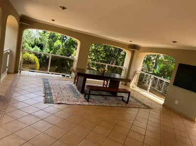 a living room with a table and a balcony at Goldpot Garsfontein 6 minutes away from SunBet Arena at Time Square Casino in Pretoria