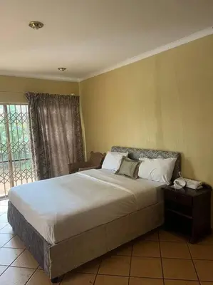 a bedroom with a large bed in a room at Goldpot Garsfontein 6 minutes away from SunBet Arena at Time Square Casino in Pretoria