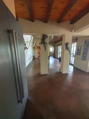 an empty room with a wooden ceiling and a hall with columns at WIFI Luxury holiday villa Zebra's Nest at Kruger in Marloth Park
