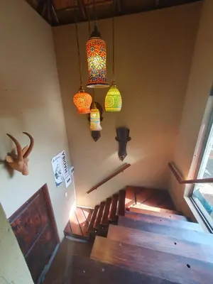 a room with a staircase with chandeliers and a stairway at WIFI Luxury holiday villa Zebra's Nest at Kruger in Marloth Park