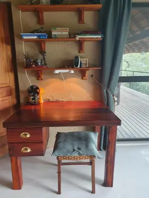 a wooden desk with a chair next to a window at WIFI Luxury holiday villa Zebra's Nest at Kruger in Marloth Park