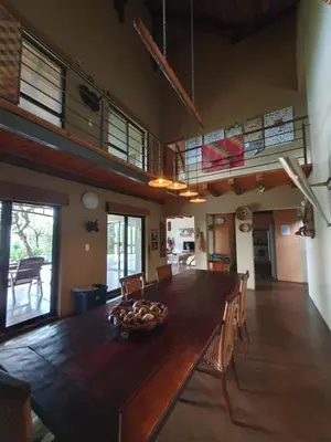 a dining room with a large wooden table and chairs at WIFI Luxury holiday villa Zebra's Nest at Kruger in Marloth Park