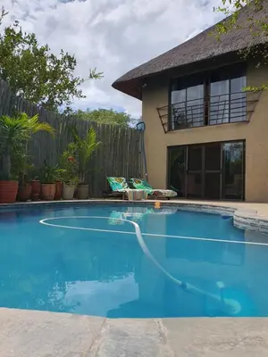 a swimming pool in front of a house at WIFI Luxury holiday villa Zebra's Nest at Kruger in Marloth Park