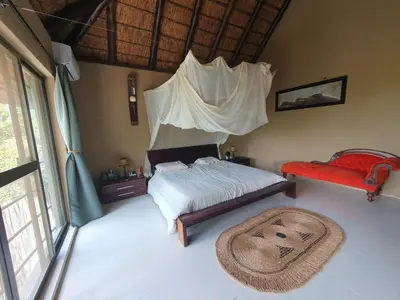 a bedroom with a bed and a rug on the floor at WIFI Luxury holiday villa Zebra's Nest at Kruger in Marloth Park