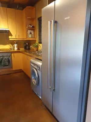 a kitchen with a refrigerator and a washing machine at WIFI Luxury holiday villa Zebra's Nest at Kruger in Marloth Park
