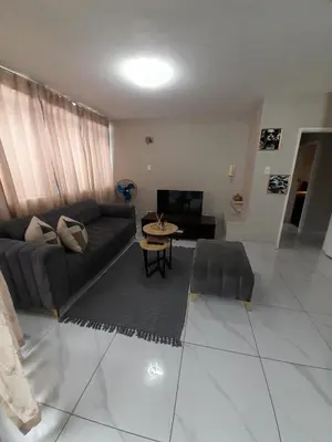 a living room with a couch and a table at Lux Living at Menlyn Place in Pretoria