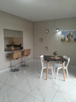 a dining room with a table and two chairs at Lux Living at Menlyn Place in Pretoria