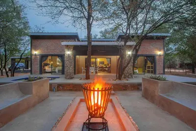 a light in front of a house with a building at Leopard Crest in Marloth Park