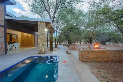 a swimming pool in front of a house at Leopard Crest in Marloth Park