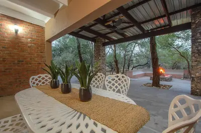 a patio with a table and chairs with plants on it at Leopard Crest in Marloth Park