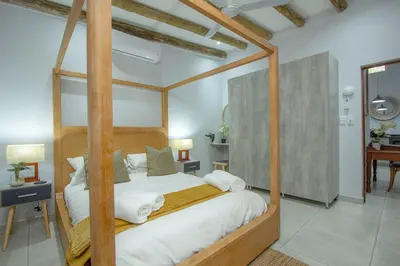 a bedroom with a canopy bed with white sheets at Cheetah Plateau in Marloth Park
