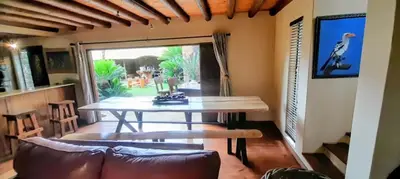 a dining room with a table and a couch at Coming Home in Centurion