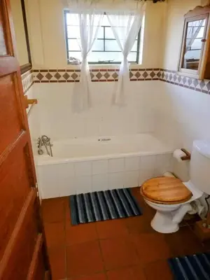 a bathroom with a toilet and a bath tub at Coming Home in Centurion
