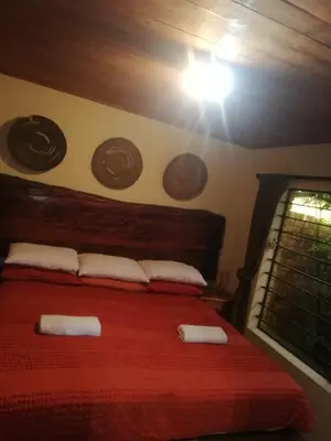a bedroom with a red bed with two white pillows at Coming Home in Centurion