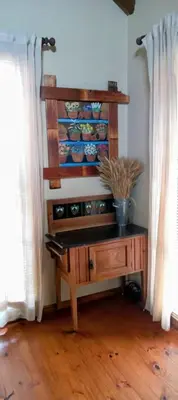 a room with a wooden table with dishes on a shelf at Coming Home in Centurion