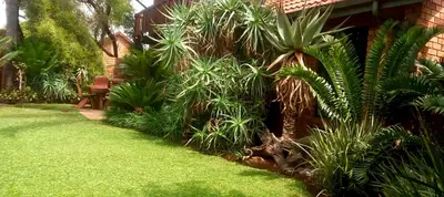 a garden with green plants next to a house at Coming Home in Centurion