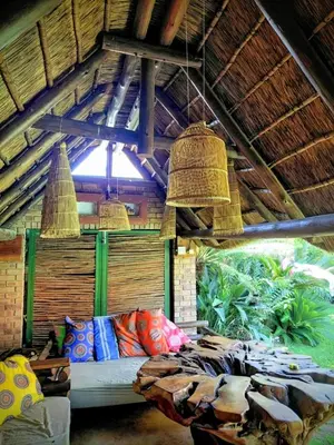 a room with a bed in a straw hut with two baskets at Coming Home in Centurion