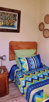 a bedroom with two beds with colorful comforters at UrbanEscape in Centurion