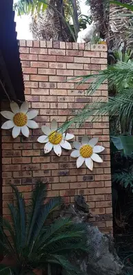 a brick wall with four daisies on it at UrbanEscape in Centurion