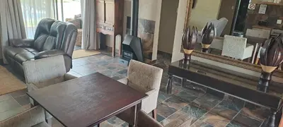 a living room with a table and chairs and a mirror at Casa de la Presa 6 in Polokwane