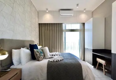 a bedroom with a large bed with a window at Capital Trilogy Apartments in Pretoria