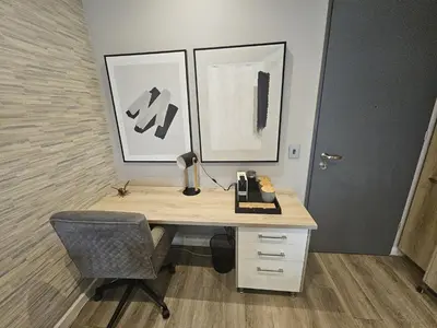 an office with a desk with a chair and two pictures at Capital Trilogy Apartments in Pretoria