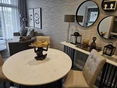 a living room with a table and chairs and mirrors at Capital Trilogy Apartments in Pretoria