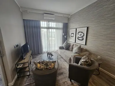 a living room with a couch and two chairs at Capital Trilogy Apartments in Pretoria