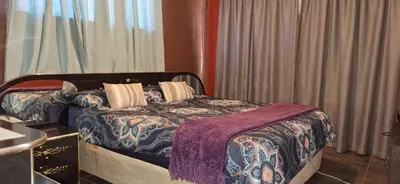 a bedroom with a bed with a purple blanket at Henning nest guest house in Centurion