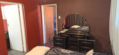 a bathroom with a dresser with a mirror at Henning nest guest house in Centurion