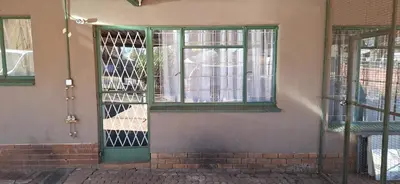 a green door on the side of a building at Henning nest guest house in Centurion