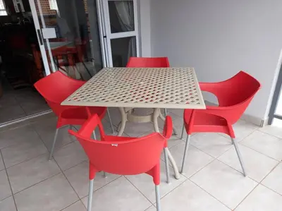a table with four red chairs around it at NO loadshedding 3km to Gautrain Short or Long stays Uncapped Wi-Fi in Centurion