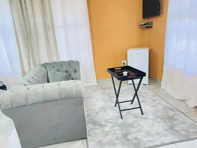 a living room with a chair and a table at Muzee Wethu Accommodations in Armburg