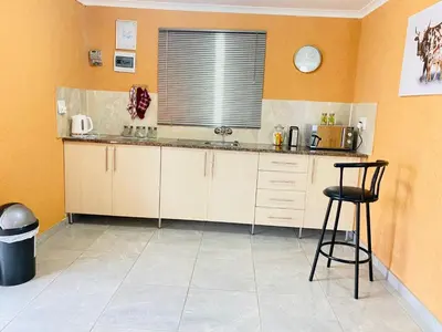 a kitchen with a counter and a chair in it at Muzee Wethu Accommodations in Armburg